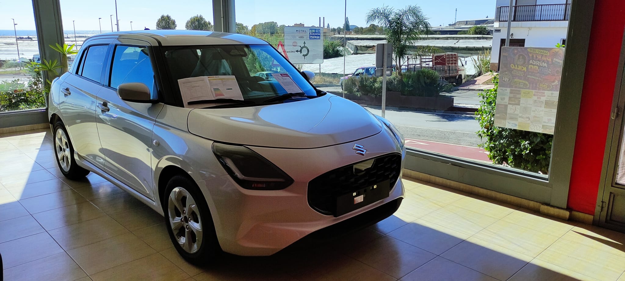 Suzuki Swift junto al ventanal de nuestras instalaciones