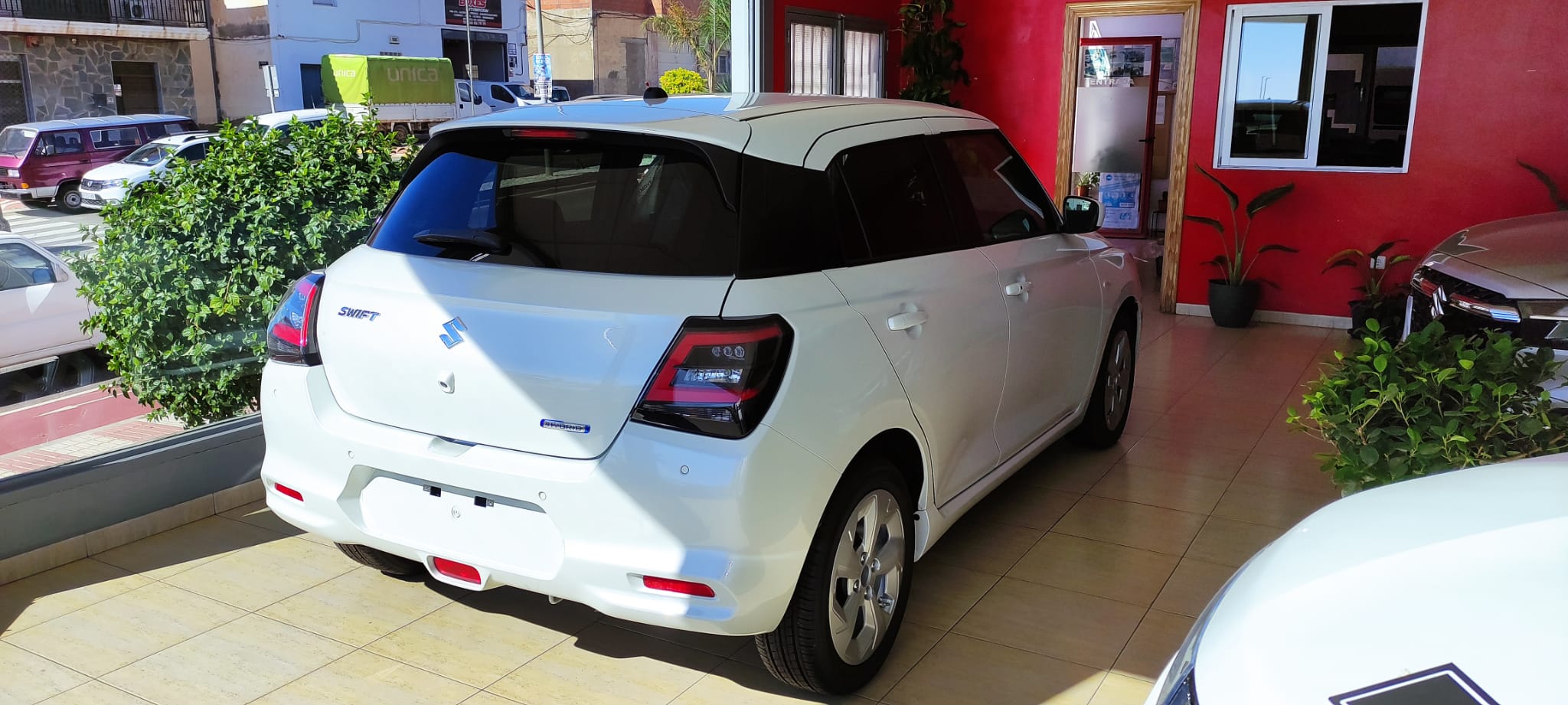 Suzuki Swift blanco junto a la oficina del taller